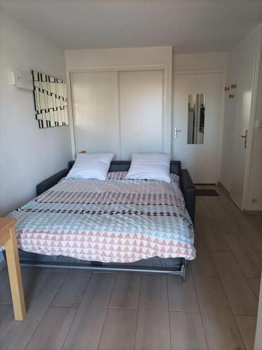 une chambre avec un grand lit avec deux oreillers dans l'établissement Beija Flor, au Cap d'Agde