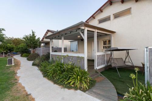 a house with a patio and a table in the yard at אצלנו בחצר in Avnei Eitan
