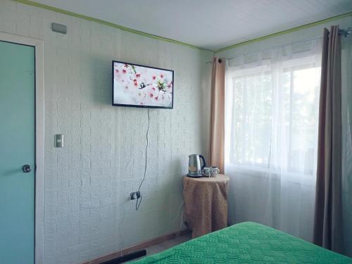 a bedroom with a bed and a window and a table at Habitación Chilota in Castro