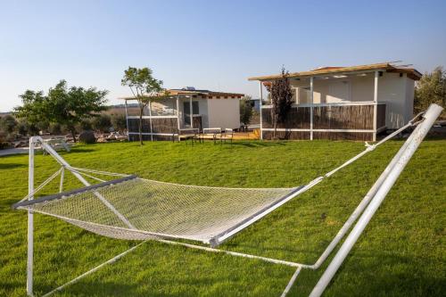 a yard with a net in front of a house at אצלנו בחצר in Avnei Eitan