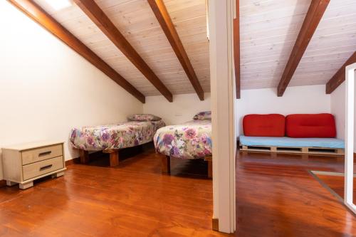 a room with two beds and a wooden ceiling at אצלנו בחצר in Avnei Eitan