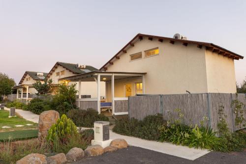 a house with a fence in front of it at אצלנו בחצר in Avnei Eitan