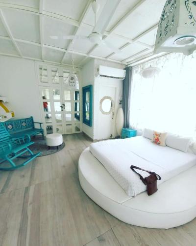 a large white bedroom with a large white bed at Homestay by the Tea Garden Dibrugarh in Dibrugarh