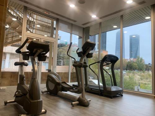 a gym with three exercise bikes in a room with windows at Hotel Madrid Chamartín, Affiliated by Meliá in Madrid