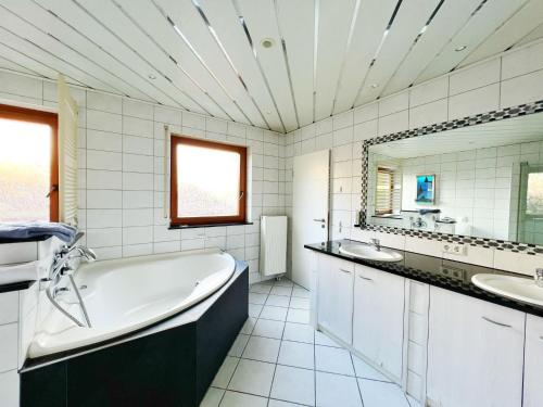 Baño blanco con bañera y 2 lavabos en Hotel Hellers Twenty Four II -24h-Check-In- en Friedrichshafen