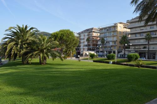 einen Park mit Palmen vor einem Gebäude in der Unterkunft Hotel Doria in Chiavari