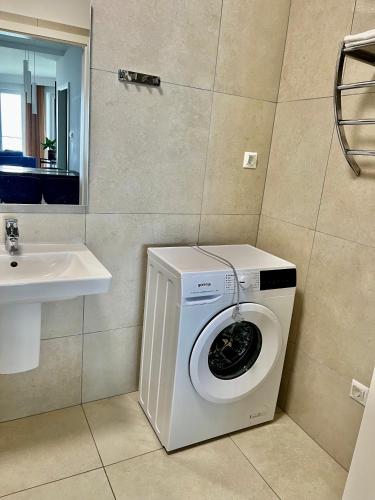 a washing machine in a bathroom next to a sink at Apartman Balaton in Keszthely