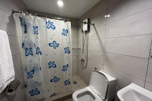 a bathroom with a shower curtain with a toilet at Verjandel Residences in Manila
