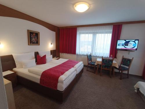 a hotel room with a bed and a table and chairs at Gästehaus Burgi in Fügen