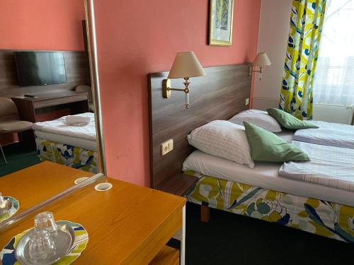 a small room with two beds and a mirror at Hotel Formanka in Hustopeče