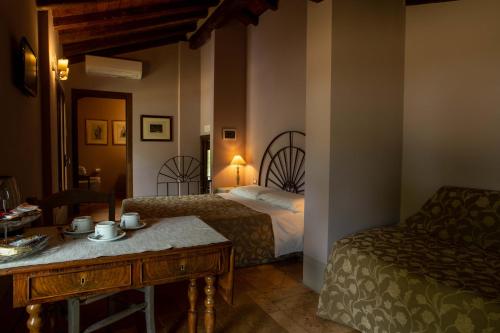 um quarto de hotel com duas camas e uma mesa e uma mesa sidx sidx em La Finestra sul Po - Agriturismo em Monticelli dʼOngina