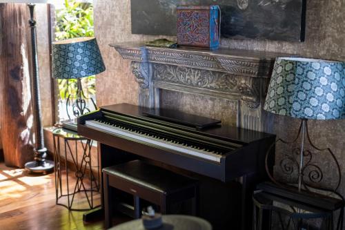 a piano in a living room with two lamps at Villa Manis Beachfront Candidasa in Candidasa