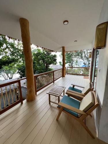 a balcony with a couch and a chair on a deck at Siam Cookies Cottage in Haad Pleayleam