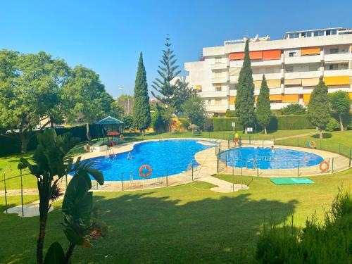 duży basen w parku obok budynku w obiekcie 797 HOLIDAY RENTALS - Piso para 4 con amplia terraza al jardin y al mar w mieście Benalmádena