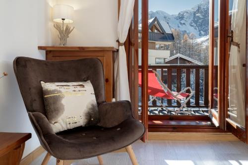 einen Stuhl mit einem Kissen auf dem Balkon in der Unterkunft HelloChalet - Foyer du Cervin 250m skiruns in Breuil-Cervinia