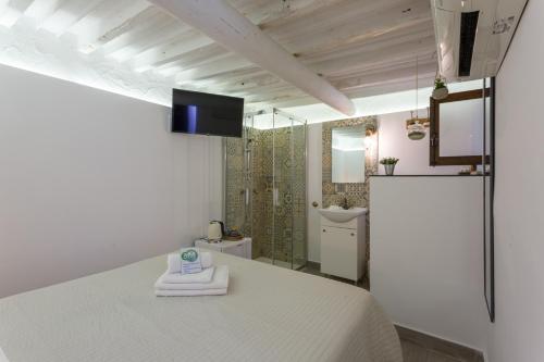 a bedroom with a white bed and a shower at Casa Catalina in Palma de Mallorca