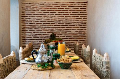 a wooden table with food and orange juice on it at RIAD MAJWRIL in Marrakesh