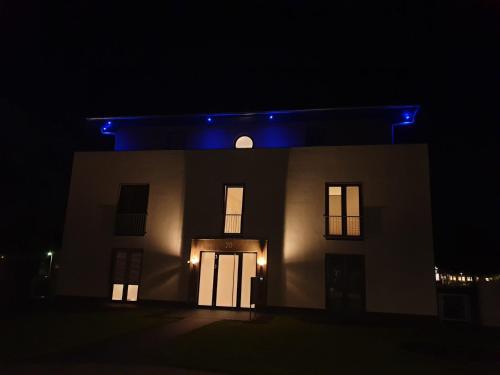 una casa illuminata di notte con luci blu di Luxus Spa Penthouse Sundowner a Göhren-Lebbin