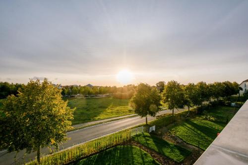 una vista aérea de una carretera con árboles y la puesta de sol en Luxus Spa Penthouse Sundowner, en Göhren-Lebbin