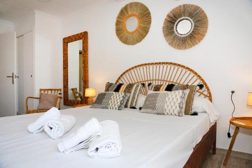 a bedroom with a large white bed with towels on it at M&C Penthouse Santa Barbara in Alicante