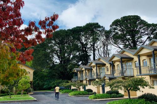 a man walking past a row of houses at Falls Mountain Retreat Blue Mountains in Wentworth Falls