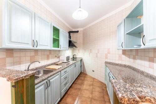 una cocina con armarios blancos y encimeras de mármol en Residence I Mirti Bianchi, en Santa Teresa Gallura