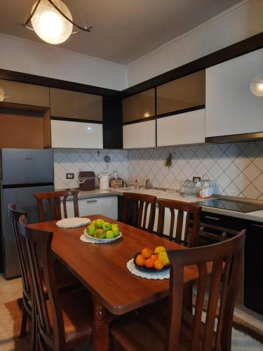 a kitchen with a wooden table with fruit on it at Vila Lordev Apartment in Korçë