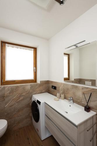 a bathroom with a sink and a toilet and a mirror at BAITA NOEMI in Livigno