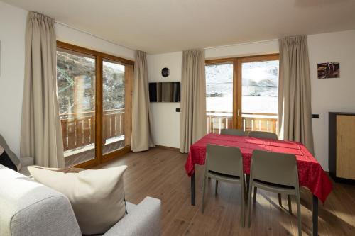 a living room with a red table and chairs at BAITA NOEMI in Livigno