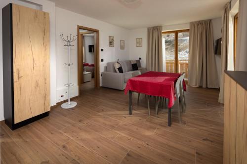 a living room with a table with a red table cloth at BAITA NOEMI in Livigno
