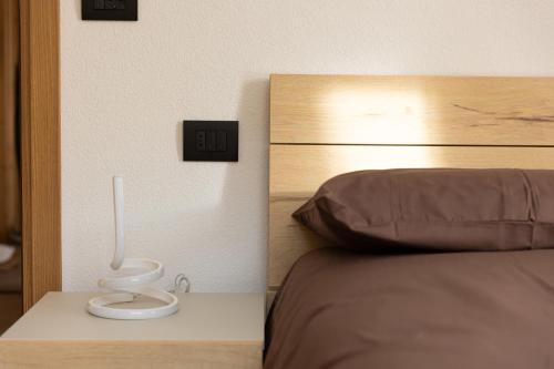 een slaapkamer met een bed met een nachtkastje ernaast bij BAITA NOEMI in Livigno