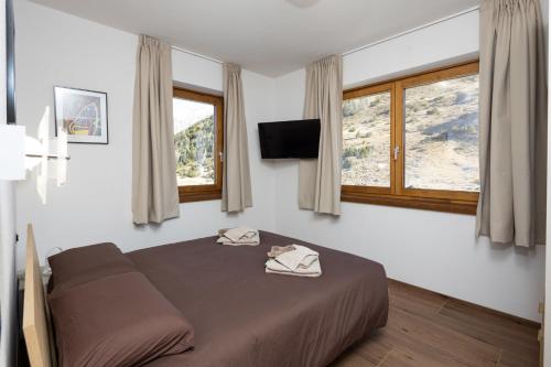 a bedroom with a bed with two towels on it at BAITA NOEMI in Livigno