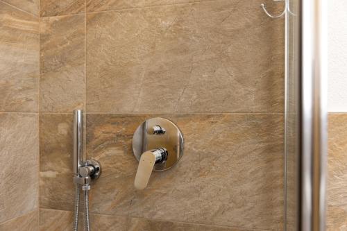 a shower with a shower head in a bathroom at BAITA NOEMI in Livigno