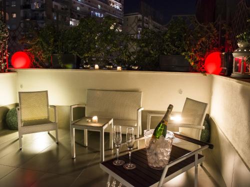 a table with two chairs and a bottle of wine at Hotel San Pietro in Naples