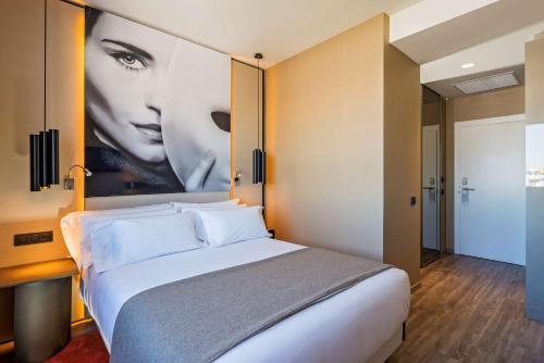 a hotel room with a bed and a painting on the wall at NH Collection Madrid Suecia in Madrid