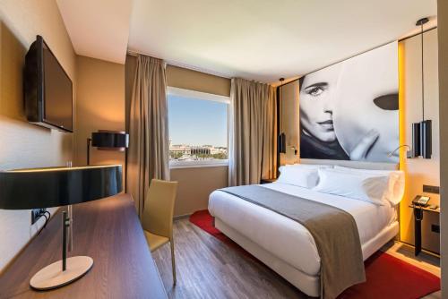 a hotel room with a bed and a television at NH Collection Madrid Suecia in Madrid