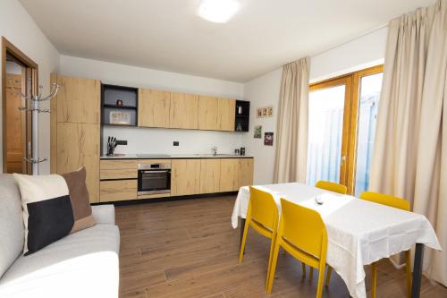 a kitchen and dining room with a table and yellow chairs at BAITA NOEMI in Livigno