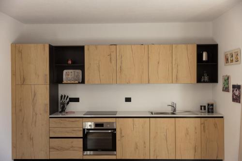 a kitchen with wooden cabinets and a sink at BAITA NOEMI in Livigno
