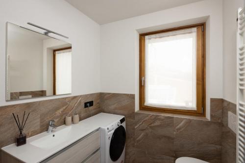 a bathroom with a sink and a washing machine at BAITA NOEMI in Livigno