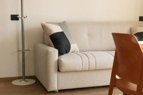 a white couch with a black and white pillow on it at BAITA NOEMI in Livigno