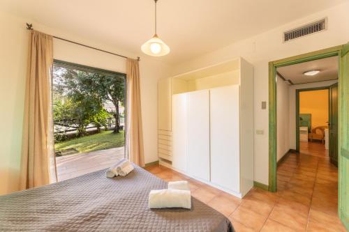 Un dormitorio con una cama y una ventana grande. en Residence I Mirti Bianchi, en Santa Teresa Gallura