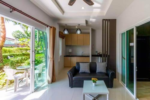 a living room with a couch and a table at Phutara Lanta Resort - SHA Extra Plus Koh Lanta in Ko Lanta