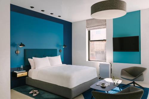 1 dormitorio con cama y pared azul en The William powered by Sonder, en Nueva York