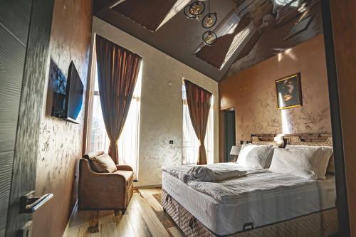 a bedroom with a bed and a chair at Вила АМРИТА in Tsigov Chark