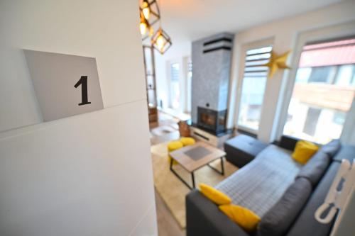 a living room with a blue couch and yellow pillows at Apartmani Dimitrije Jahorina in Jahorina
