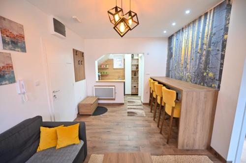 a living room with a table and yellow chairs at Apartmani Dimitrije Jahorina in Jahorina