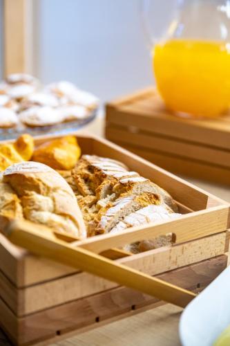 a wooden tray filled with slices of bread on a table at Lizbon South Bed in Barreiro