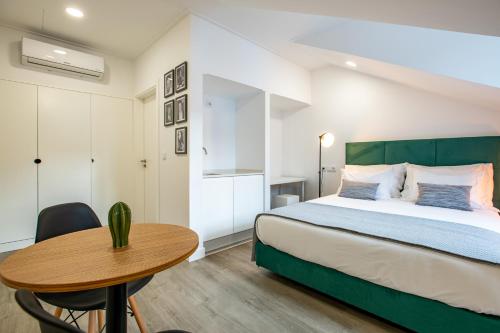 a bedroom with a bed and a wooden table at Lizbon South Bed in Barreiro