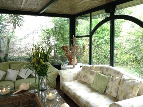 a screened in porch with a couch and a table at Hotel Villa Maremonti in Marina di Massa