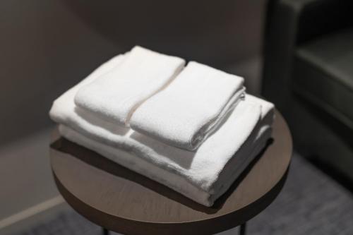 un mucchio di asciugamani bianchi seduti sopra un tavolo di EN HOTEL Ise a Ise